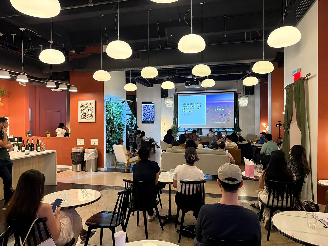Wide view of the room, attendees at tables and the bar during a talk