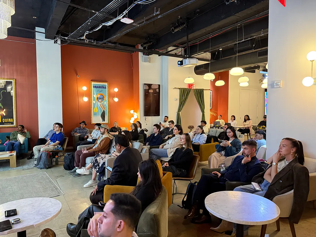Attendees seated in rows, listening to a presentation
